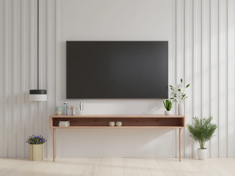 Mounted TV bracket installation on a white feature wall in a modern Singapore living room with minimalist decor.